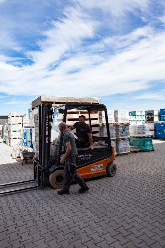 Gabelstapler transportiert Baumaterialien auf dem Betriebshof.