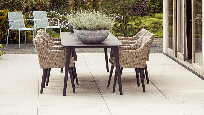 Steintisch mit grauer Platte auf einer Terrasse 