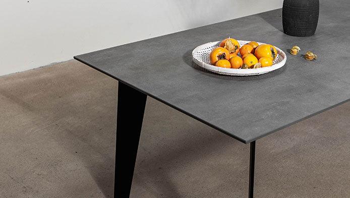 Tisch mit Keramikplatte und schwarzen Gestell seitlich