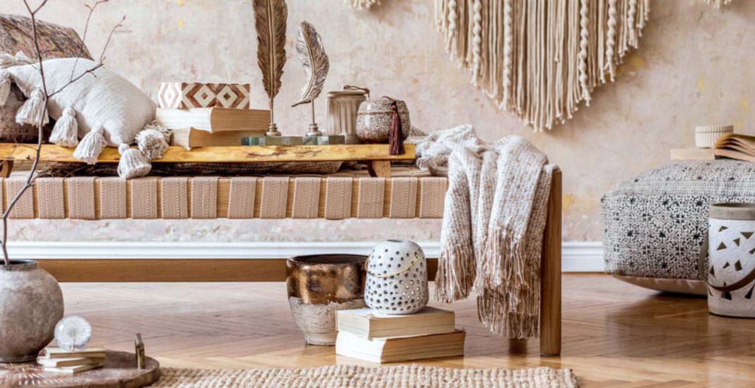 Raum mit Boho Stil Einrichtung mit beigem Holzbett, Leinentüchern und Holzboden
