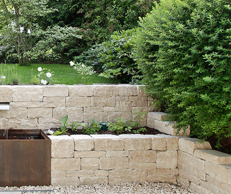 Beige Mauersteine die als Mauer und Hochbeet eingesetzt werden, mediterranee Optik, Garten und Naturstein Kategorie
