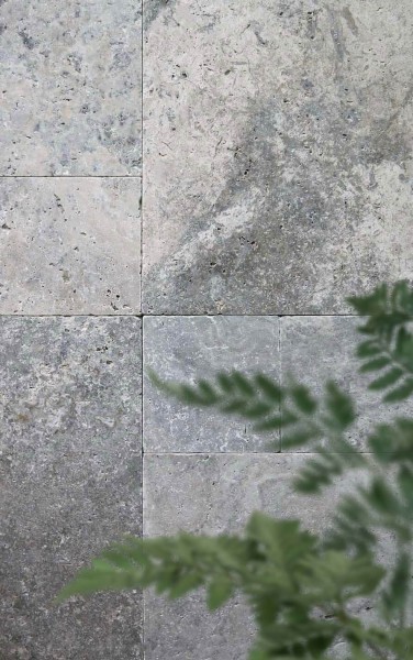 Terrassenplatten Travertin Silver im römischen Verband mit Pflanzenzweig